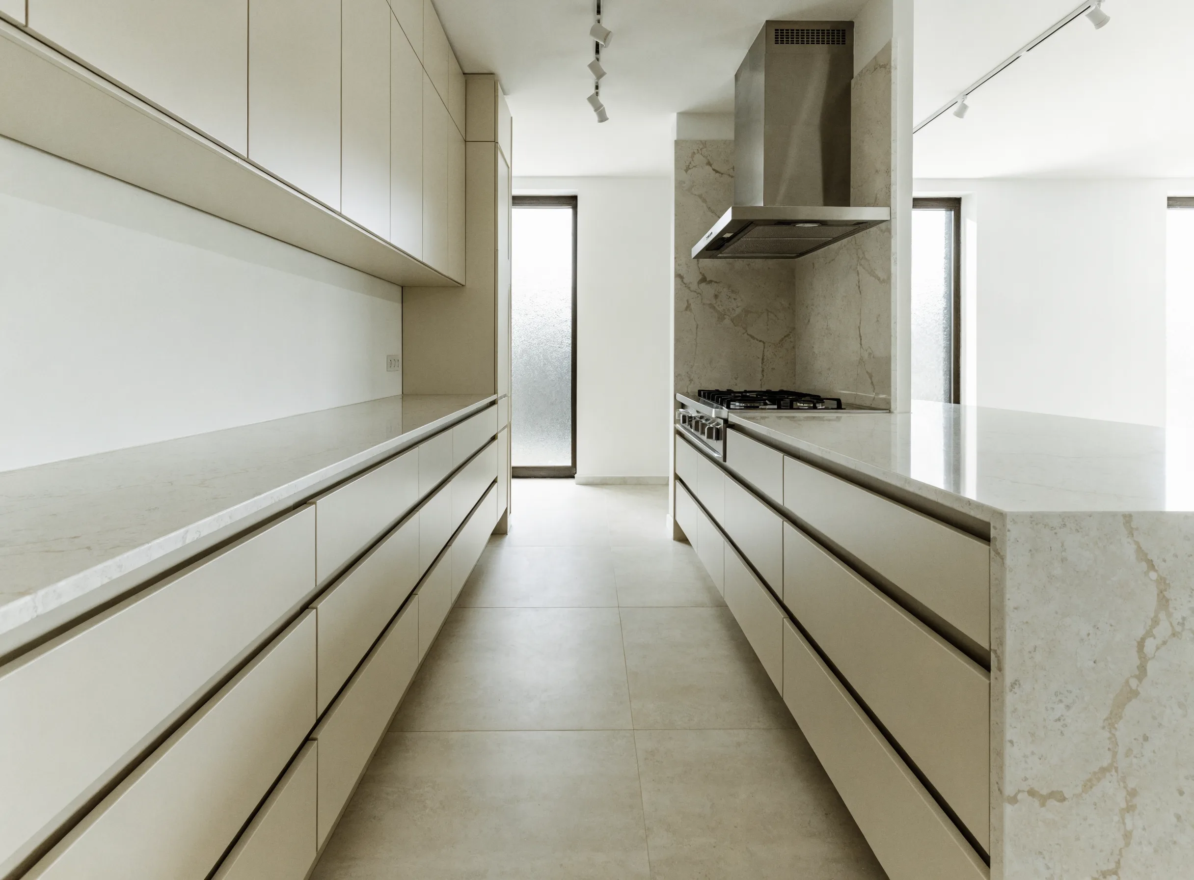 Custom kitchen design Boca Raton: a planned kitchen with a wide walkway between the wall run and the island, landing counter on both sides of the range and deep drawer banks