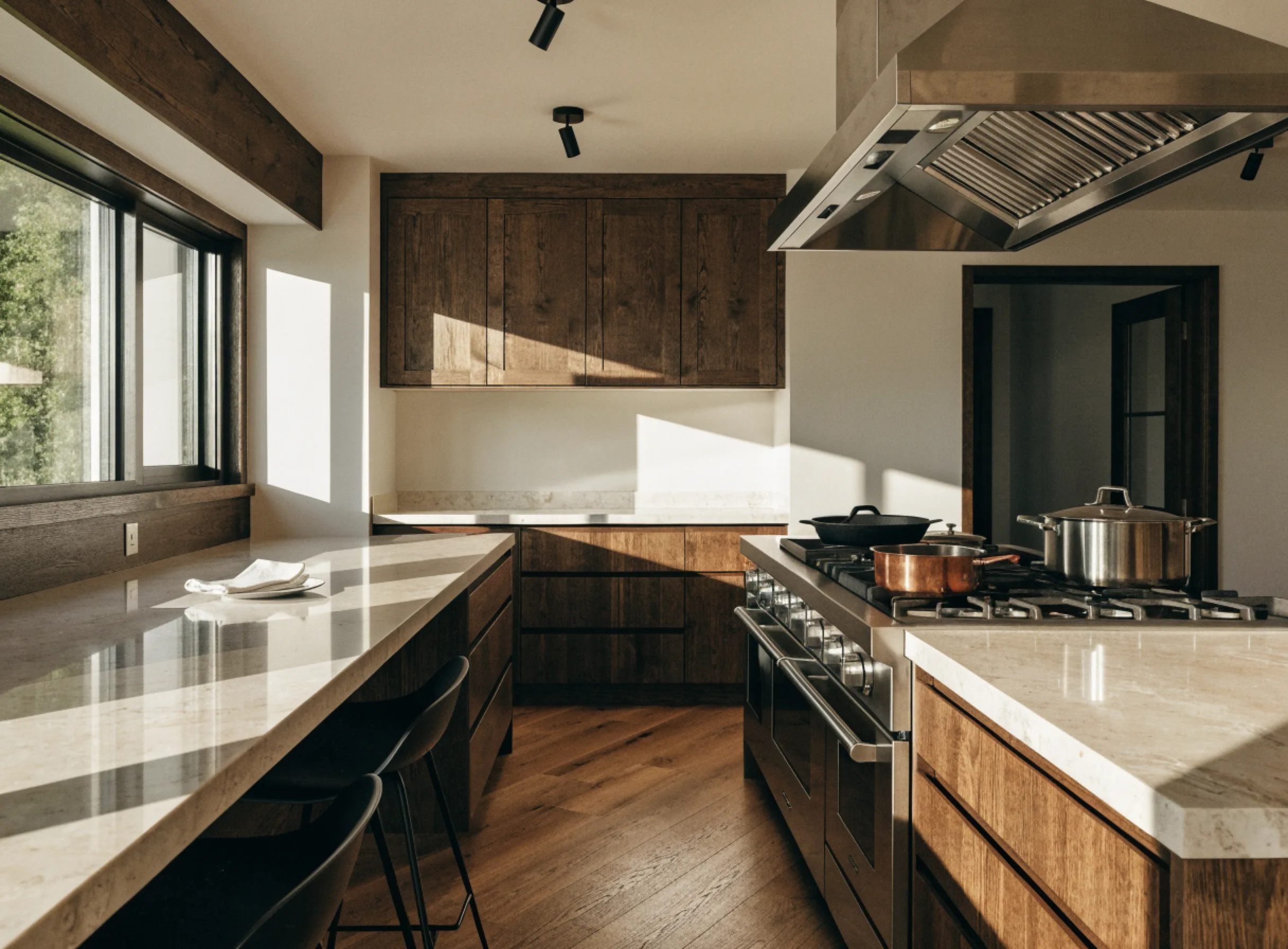 Kitchen island installation Boca Raton: a finished island with seating on one side, a stone top and deep drawers facing the range