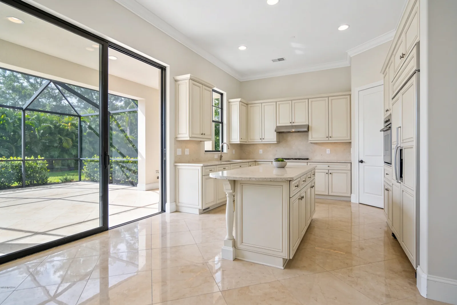 A finished villa kitchen with the sliding doors open to a screened patio