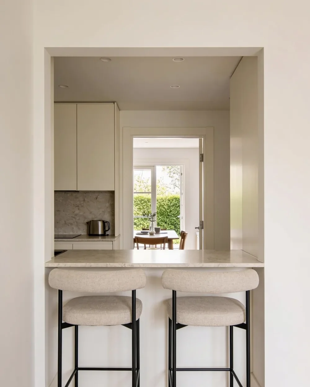 A compact kitchen peninsula with a quartz top and two stools tucked under the overhang