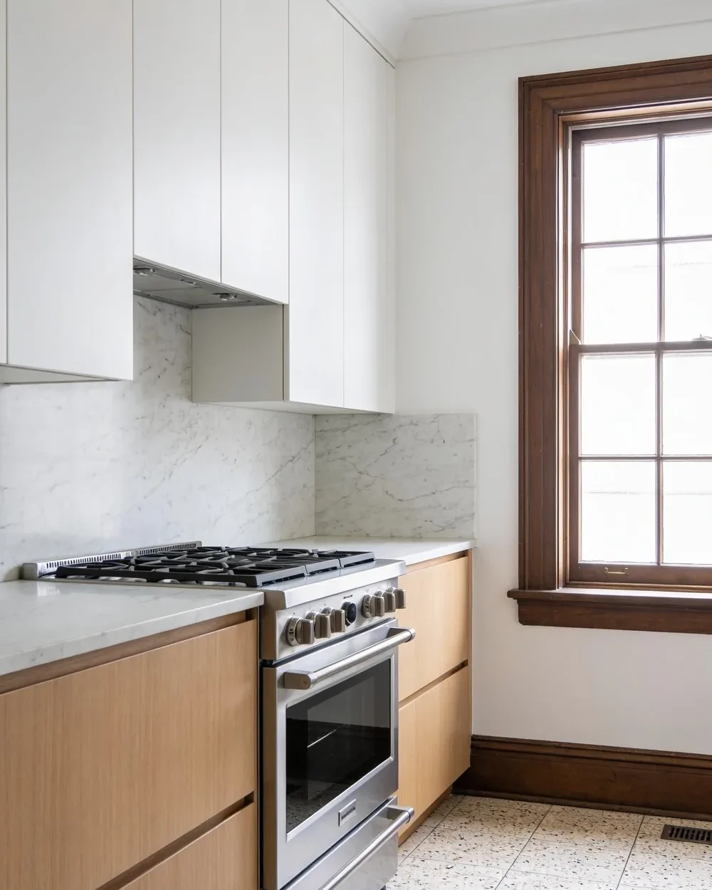 Kitchen remodeler near Florida Atlantic University: a rebuilt kitchen in an older single storey house, with pale oak base cabinets, white uppers and a deep window sill