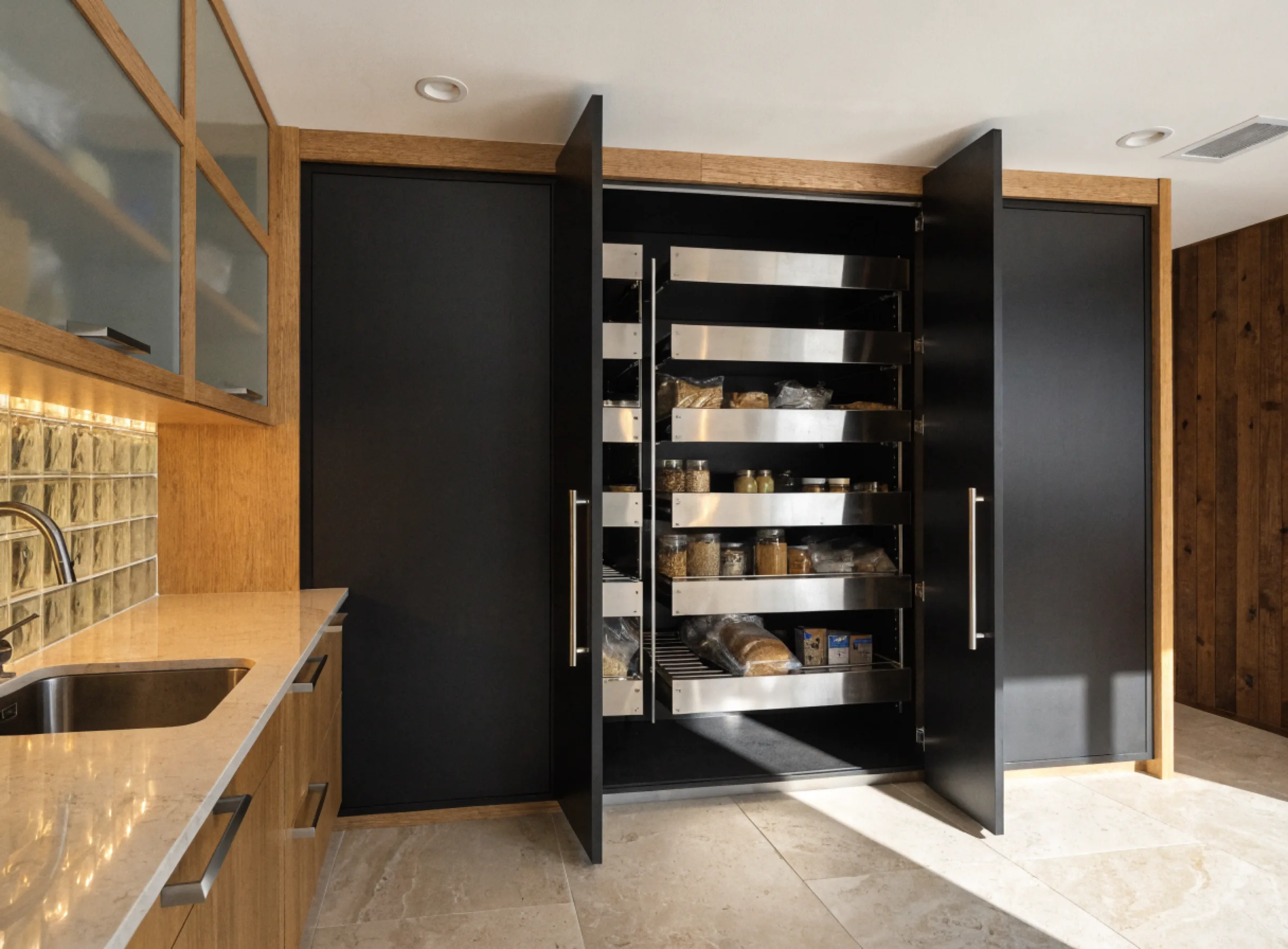 Pantry installation Boca Raton: a tall floor to ceiling pantry cabinet with pull out shelves, built into the end of a kitchen run