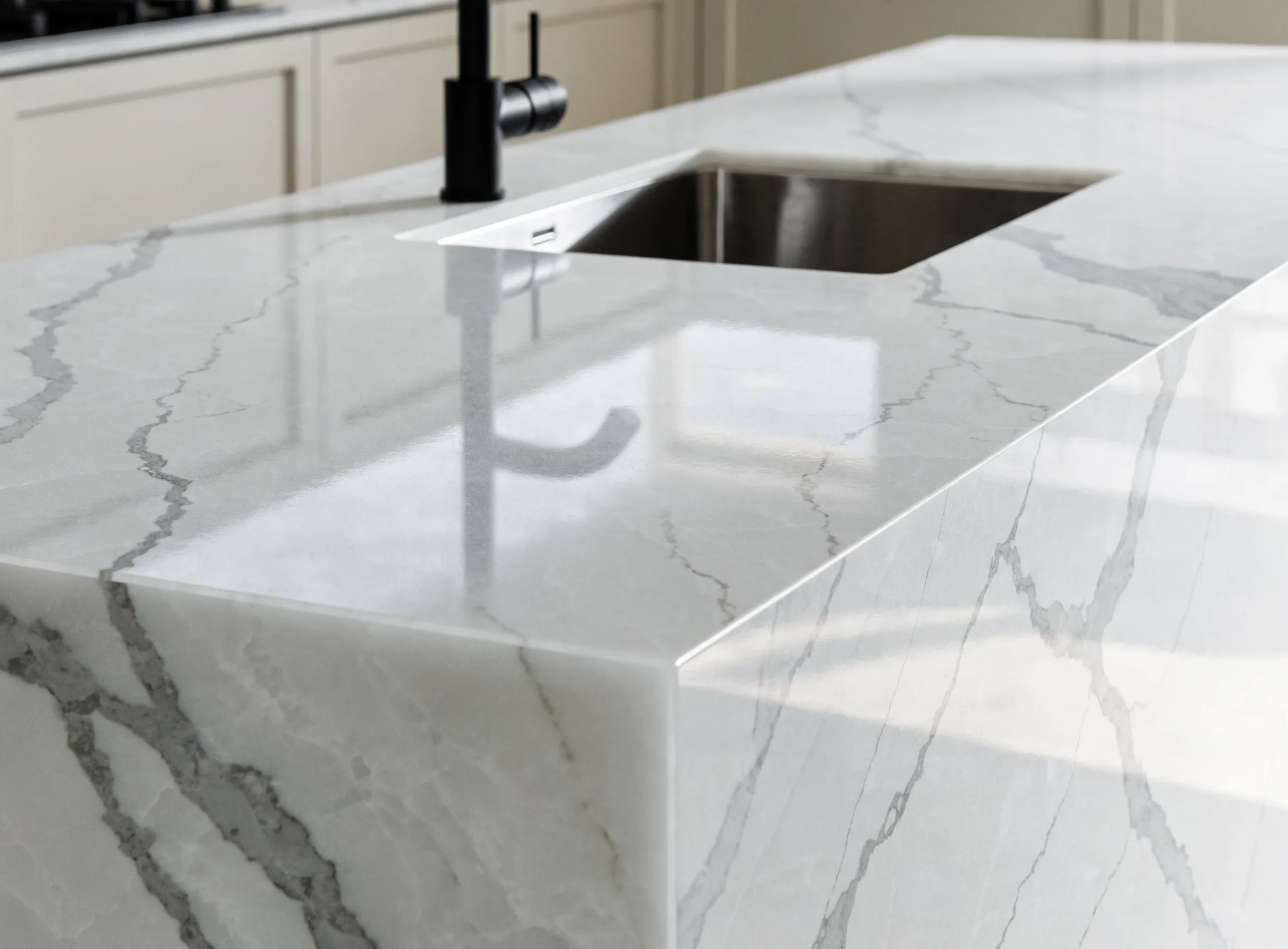 Quartz countertop run with a waterfall end panel on the island and an undermount sink